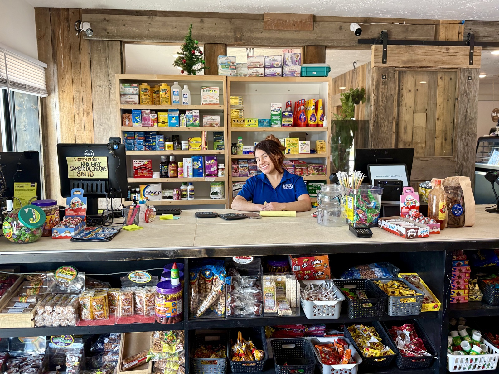 A smiling employee at the Monte Sinai checkout counter