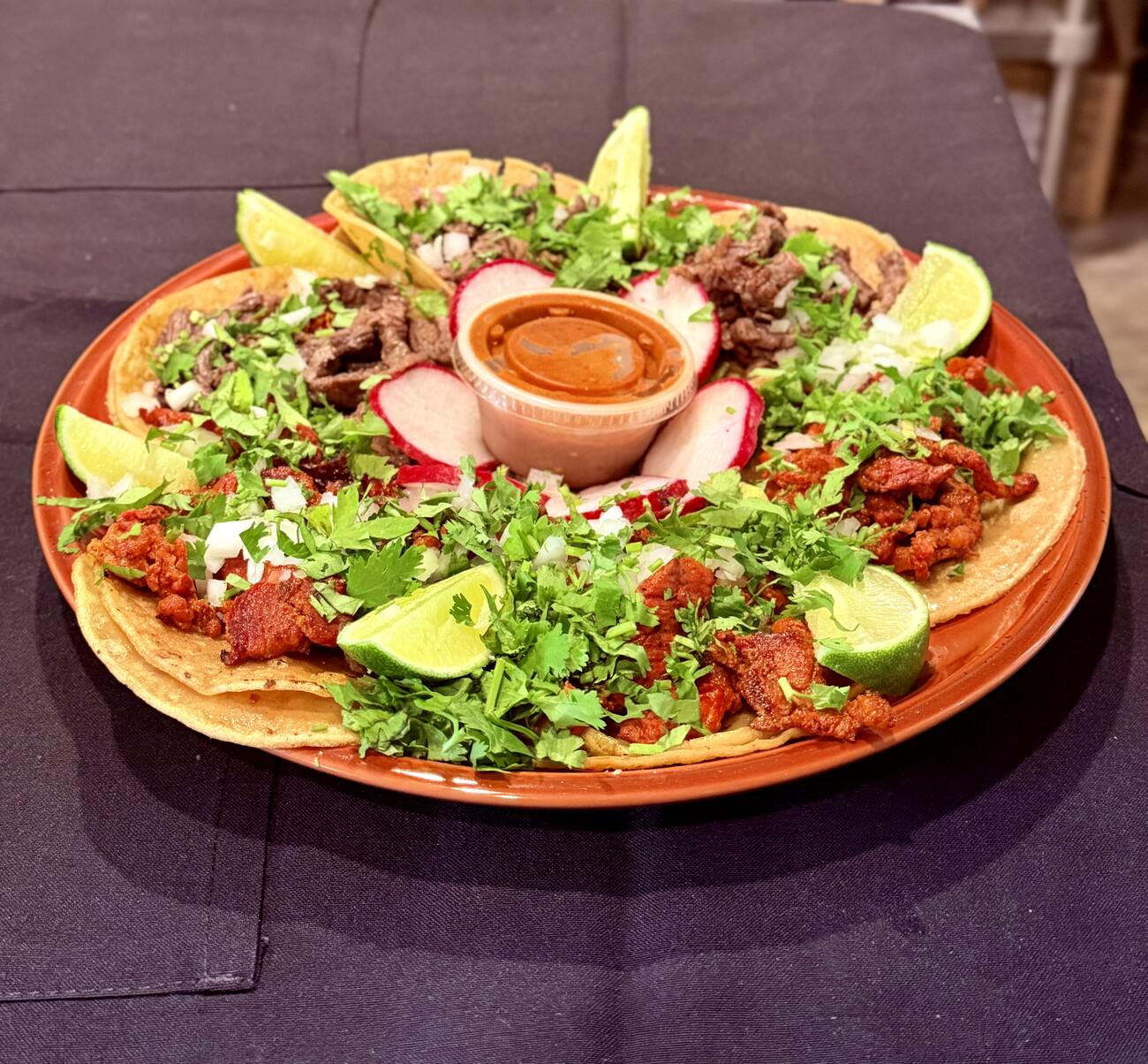 A platter of asada and pastor tacos with radish, lime and cilantro at Pampano's Cafe